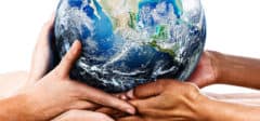 Many mixed hands cradling our home planet. Shows environmental awareness and an acceptance of responsibility for the care of our earthly home.